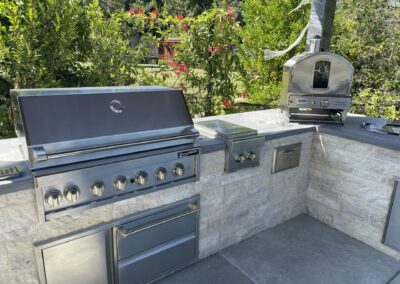 Natrual stone outdoor cooking range, with pizza oven.